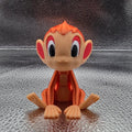 Small orange and beige figurine on a textured metallic surface