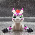Toy figure of a creature with white, purple, and black colors on a textured surface